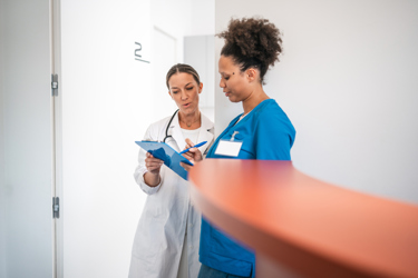 Doctor and nurse having a conversation about a patients chart (high res)