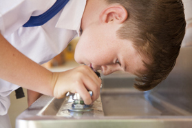 child drinking from water fountain-GettyImages-908165614