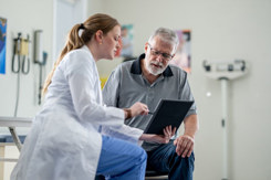 Senior man talking with doctor-GettyImages-2048635835