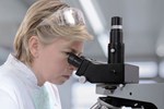 Researchers Discover Potential New Treatment Method For ALS female researcher at microscope_450x300