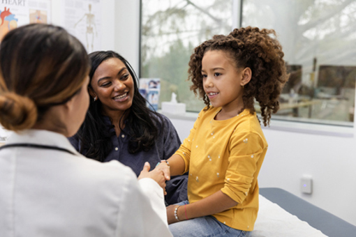 female doctor shakes hands with her young female patient-GettyImages-2123113270