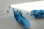 GettyImages-2098817477-vaccine-needle-syringe-gloved-hands-laboratory
