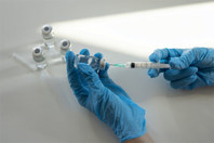 GettyImages-2098817477-vaccine-needle-syringe-gloved-hands-laboratory