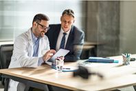 GettyImages-1204781345 doctor tablet meeting