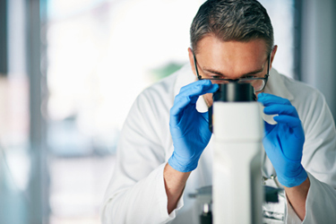 Scientist with microscope-GettyImages-543355608