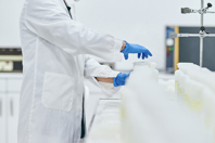 GettyImages-1196052154-scientist-in-lab-with-bottles