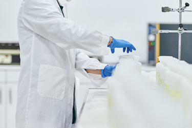 GettyImages-1196052154-scientist-in-lab-with-bottles