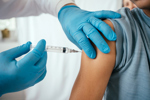 Doctor administering vaccine to teenager in doctor's office-GettyImages-2233089442