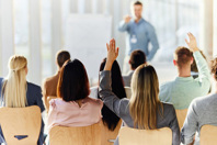 businesswoman asking question in education event-GettyImages-2198836359