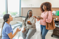 Nurse, patient, and daughter talking about prescription medication in a hospital-GettyImages-2210890101