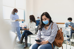 Adult woman sits in waiting room-GettyImages-1372189785