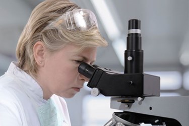 female researcher at microscope female researcher at microscope